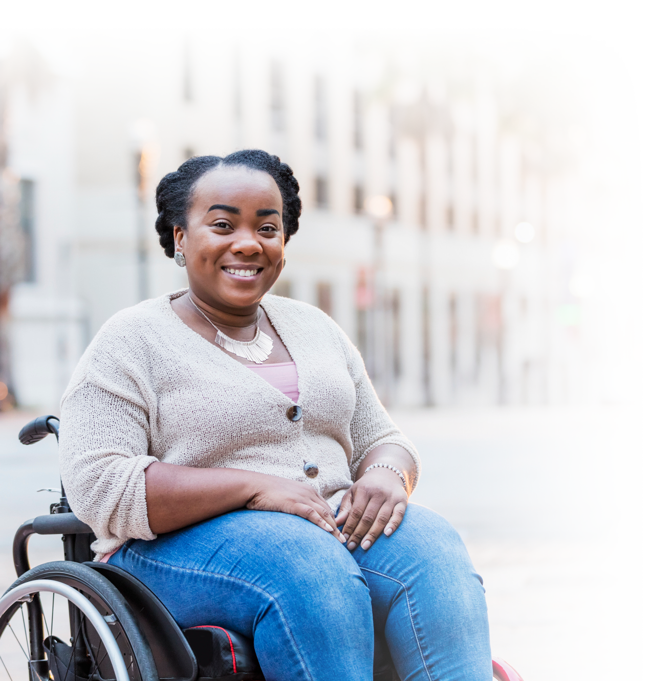 Photo of a young woman in a wheelchair on the city sidewalk.