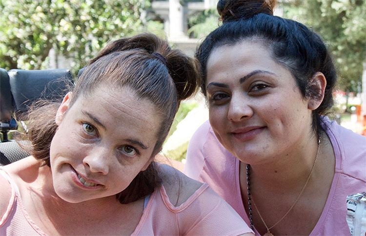 Photo of two ladies at an outdoor event together.